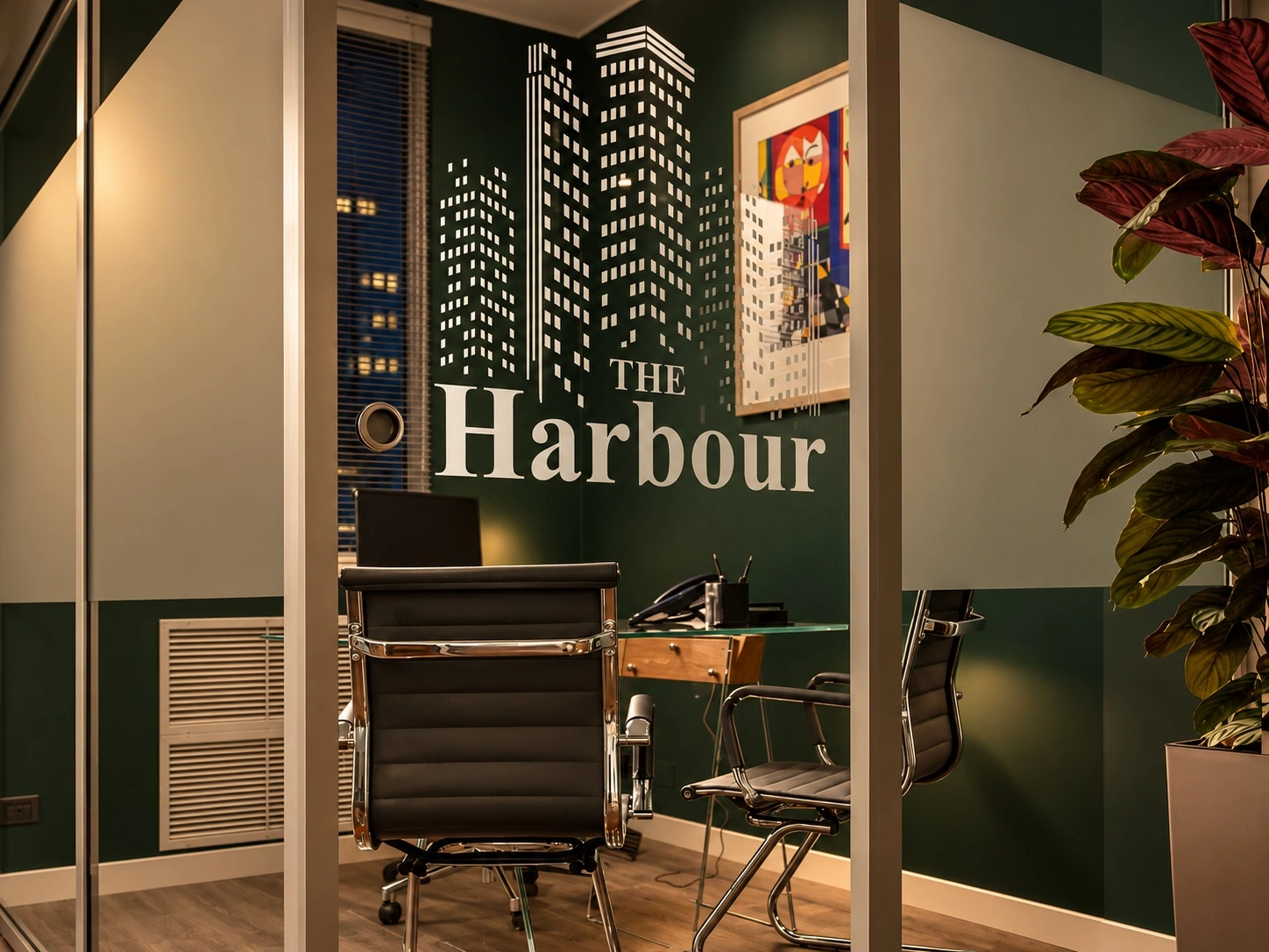 Parete vetrata e logo The Harbour in luce serale